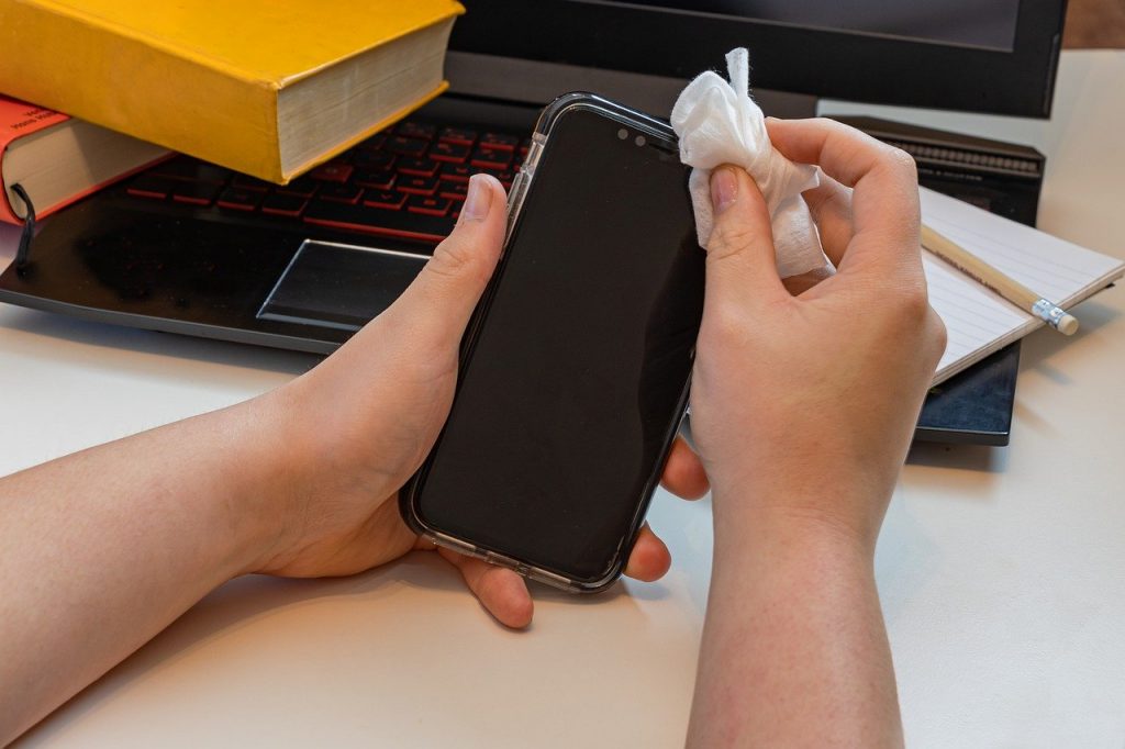 Person wiping down their smartphone